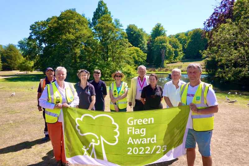 Staff and volunteers with Councillor Richardson holding the Green Flag Award 2022/23 flag at Kearsney Abbey.