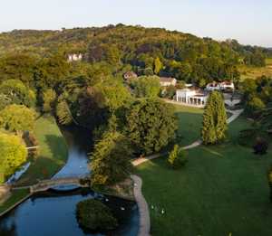 An aerial photograph of Kearsney Abbey, showing the footbridge, lake and cafe.