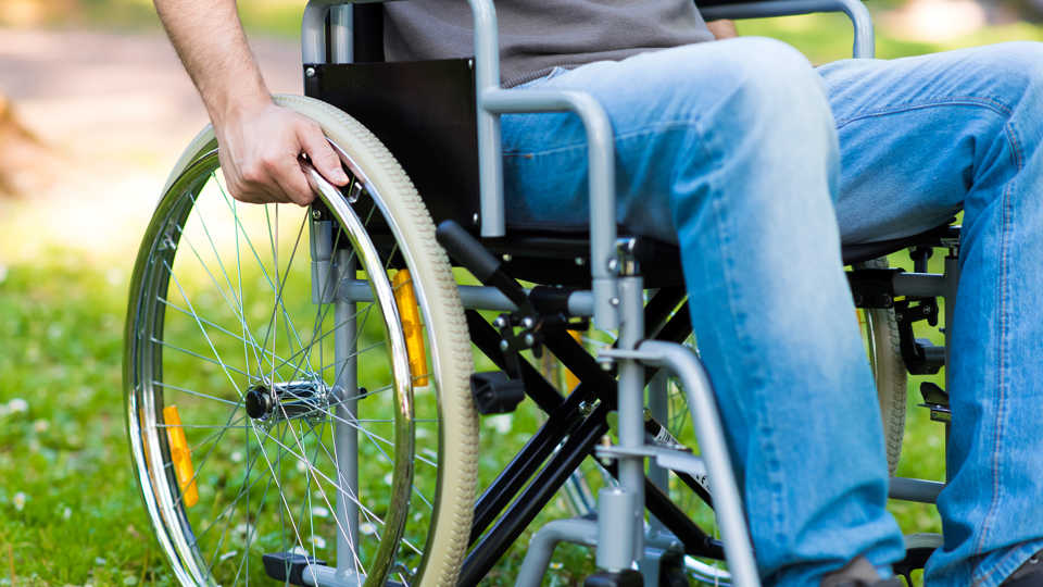 A photograph of a person in a wheelchair.