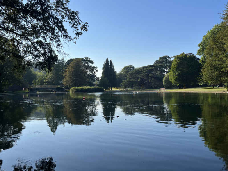 A photograph of the lake in Kearsney Abbey, looking towards the footbridge over the lake.