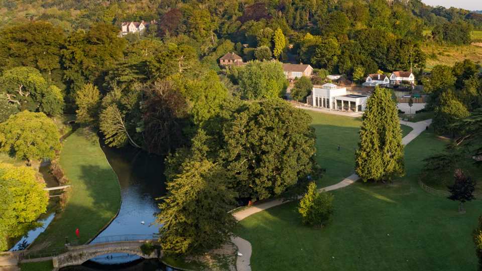 An aerial photograph of Kearsney Abbey, showing the footbridge, lake and cafe.