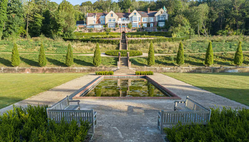 A photograph of the ornamental pond in Russell Gardens with Kearsney Court in the background.